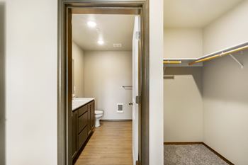 The view of a bathroom from the doorway of a living room with a door open